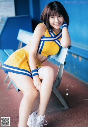 A woman in a cheerleading uniform holding a baseball bat.