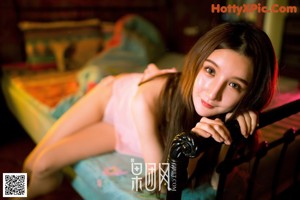 A woman sitting on a couch holding a rose.