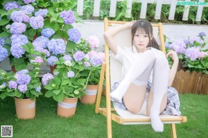 A woman in a white shirt and skirt posing for a picture.