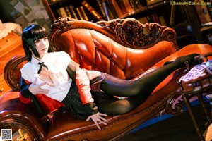 A woman sitting on top of a brown leather chair.
