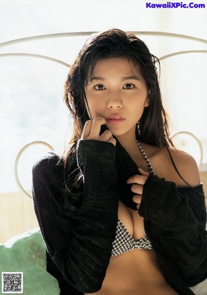 A woman in a black and white bikini posing for a magazine.