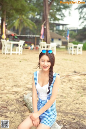 A woman in a blue and white dress sitting at a table.