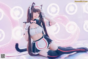 A woman in a maid outfit sitting on a chair.