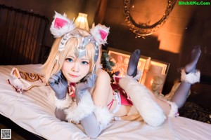 A woman in a bunny costume sitting on a bed.