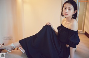 A woman in a black dress posing for a picture.