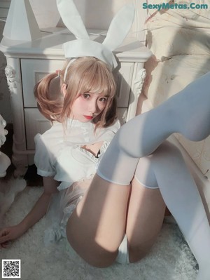 A woman in a white dress holding a white rabbit.