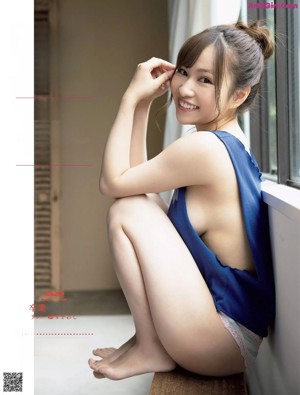 A woman in a beige bodysuit posing for a magazine.