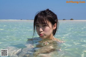 A woman in a bikini standing in the ocean.