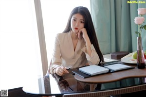 A woman in a skirt and high heels leaning over a table.
