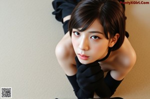 A naked asian woman sitting on a red chair.