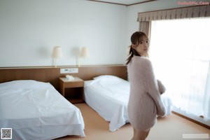 A woman in a pink fur coat with her eyes closed.