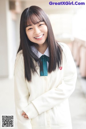 A young woman in a school uniform posing for a picture.