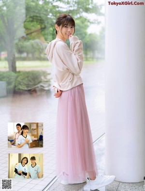 A woman in a white shirt and white pants posing for a picture.