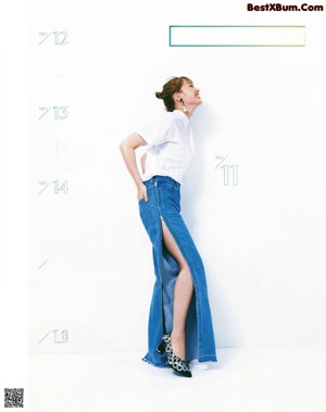 A woman in a black top and blue pants.