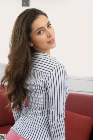 A woman in a white shirt and black skirt posing for a picture.