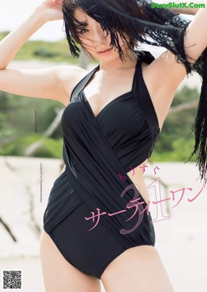 A woman in a yellow bikini standing on a dirt road.