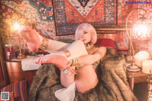 A woman sitting on a rug in a living room.