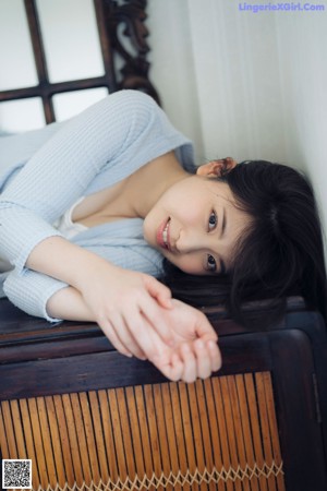 A woman sitting on a bench with her legs crossed.