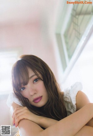 a woman in a white top and blue jeans posing for a picture