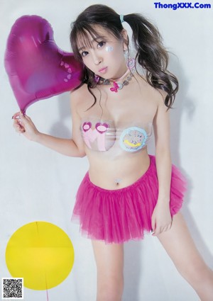 A woman in a bikini holding a yellow frisbee.